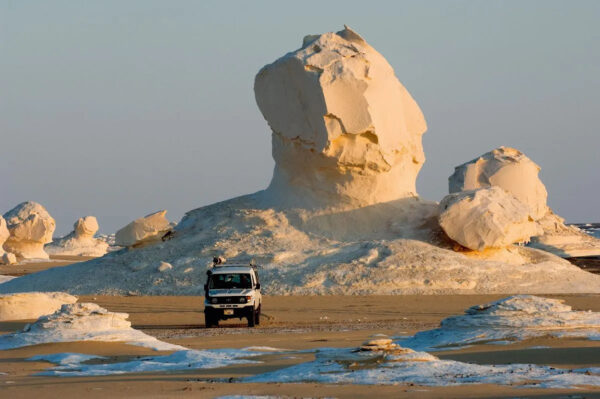 Eine Sandsteinformation in der Weißen Wüste, davor ein Truck