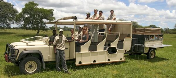 Auf einem Safari-Fahrzeug in der Natur befinden sich mehrere Passagiere und Guides