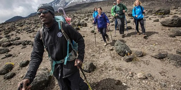 Eine Gruppe Wanderer läuft durch eine steinige Berglandschaft
